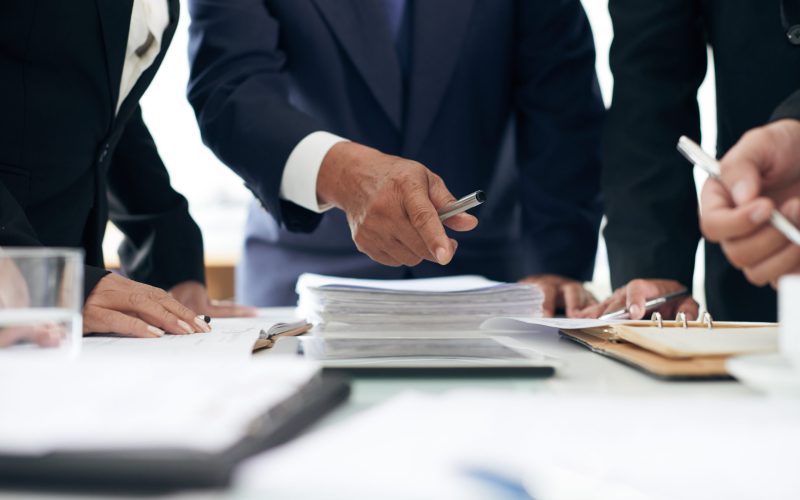 Cropped image of lawyer showing evidence he found in papers to coworker