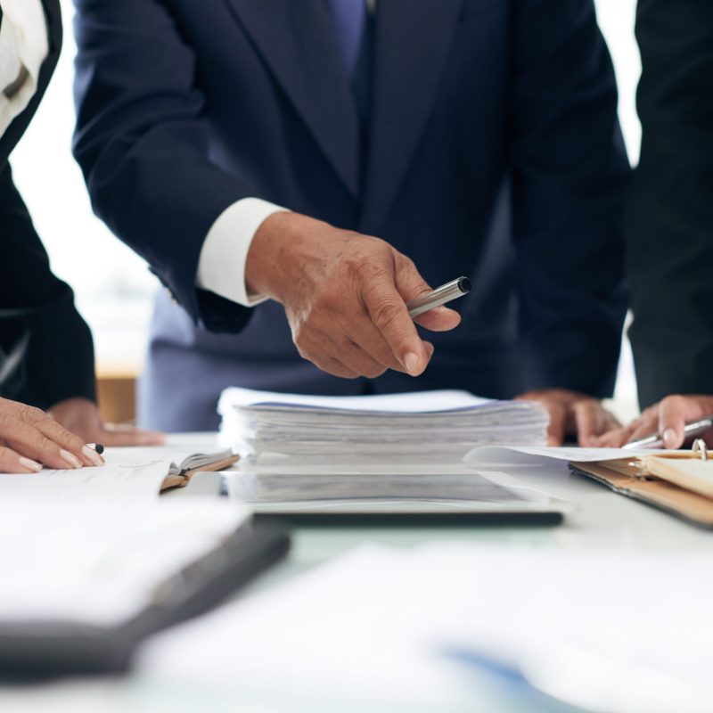 Cropped image of lawyer showing evidence he found in papers to coworker